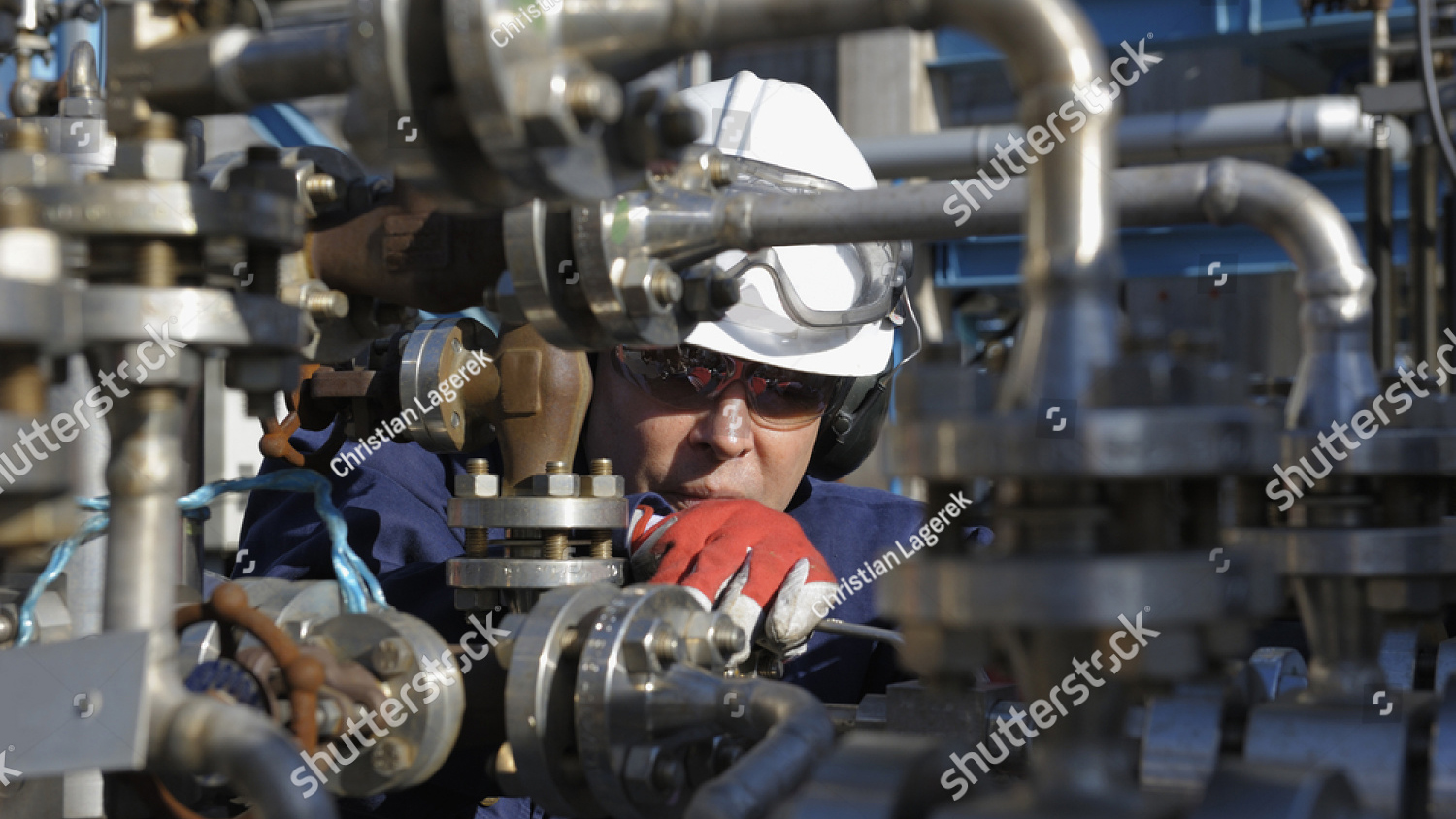 stock photo engineer standing behind pipeline machinery inside oil refinery 25586191