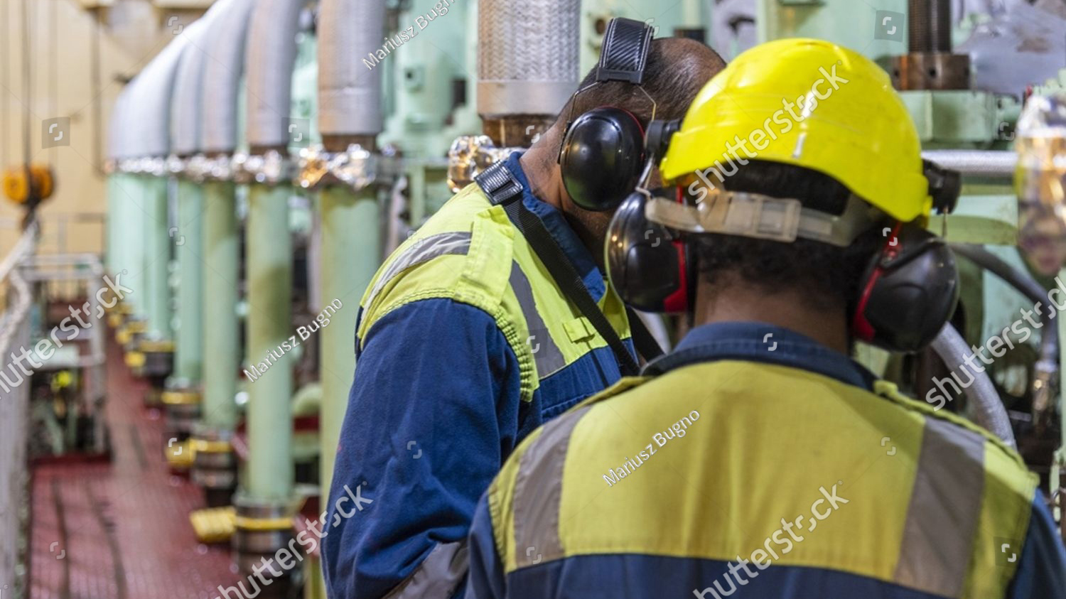 stock photo two marine engineers inspecting and monitoring main engine parameters inside a ship engine room 2729390101